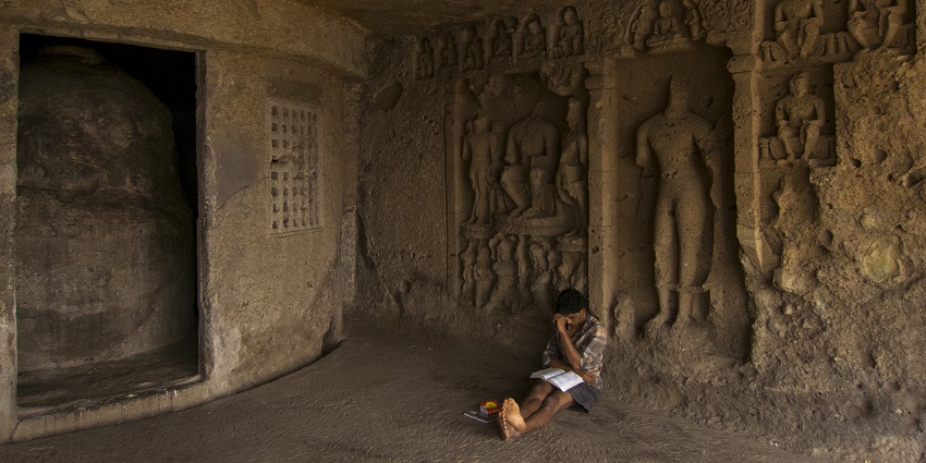 An image of a student reading a book in Mahakali Caves