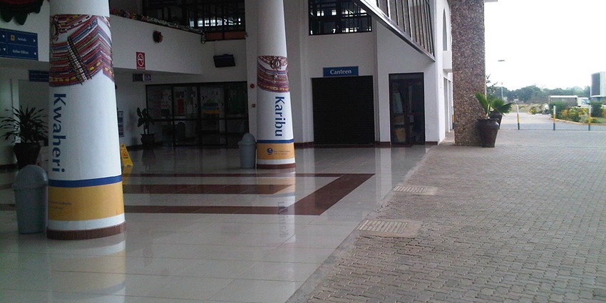Entrance to the Malindi international airport showing pillars, potted plant and glass window