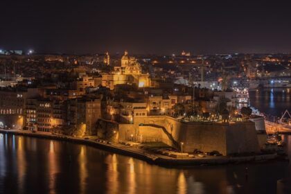 Senglea in Malta at night with well-lit buildings and cars parked on distant streets