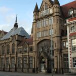 An image showing the exterior of the Manchester Museum, highlighting its historic architecture.