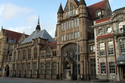 An image showing the exterior of the Manchester Museum, highlighting its historic architecture.