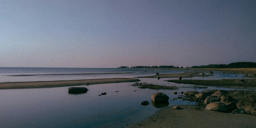 Scenic view of the evening blue sky over the rocky shore near the beach.