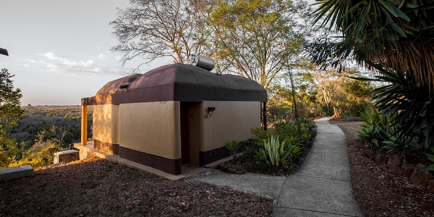Masai manyatta with a hut-like structure and narrow paths surrounded by greenery.