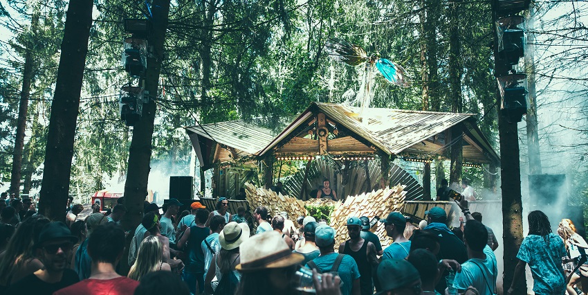 Image of people partying - Israel music festival in the serene forest setting