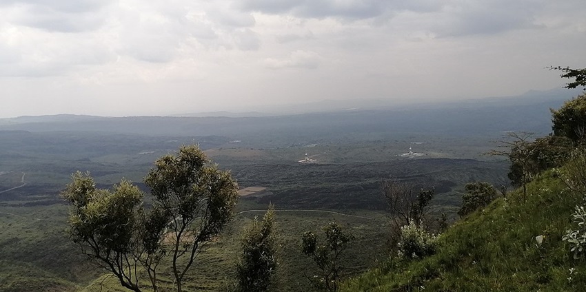 Menemgai crater landscape from above the hill covered in greenery from the edge