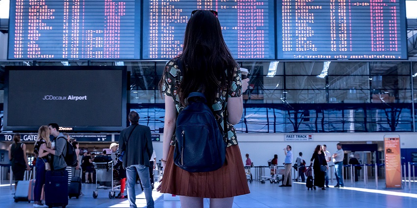 A view of travellers walking and waiting in a modern airport terminal with bright lighting