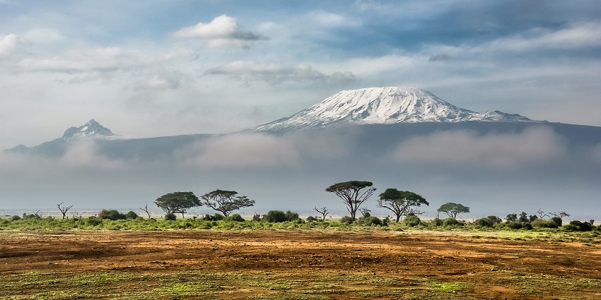 Landscape of Amboseli National Park with visible peaks of Mount Kilimanjaro covered in snow