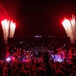 An image of the festival-goers having fun at music events, surrounded by vibrant lights