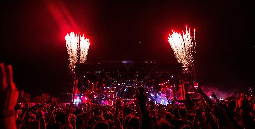 An image of the festival-goers having fun at music events, surrounded by vibrant lights