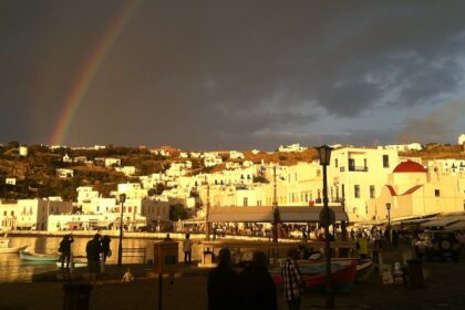 Mykonos with golden yellow sunlight hitting the white buildings, making a rainbow