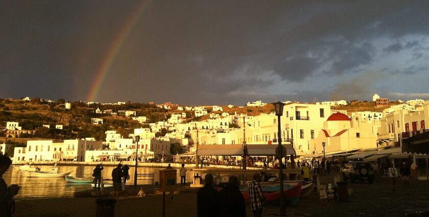 Mykonos with golden yellow sunlight hitting the white buildings, making a rainbow