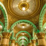 A wide view of a well-lit Mysore Palace with a dramatic background of clouds in Mysore, Karnataka.