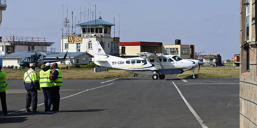 Wilson airport runway showing a plane ready for take off and maintenance staff in uniform