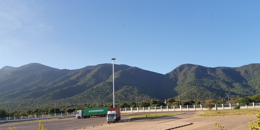 Namanga road on the border between Kenya and Tanzania with two trucks departing.