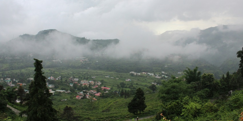 Monsoon clouds descent into a valley in the Himalayas.