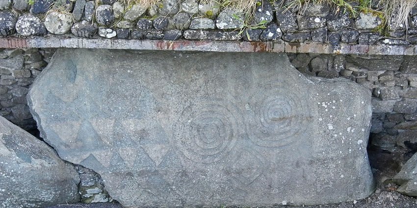 An image of Newgrange, an ancient passage tomb with a grass mound for travellers.