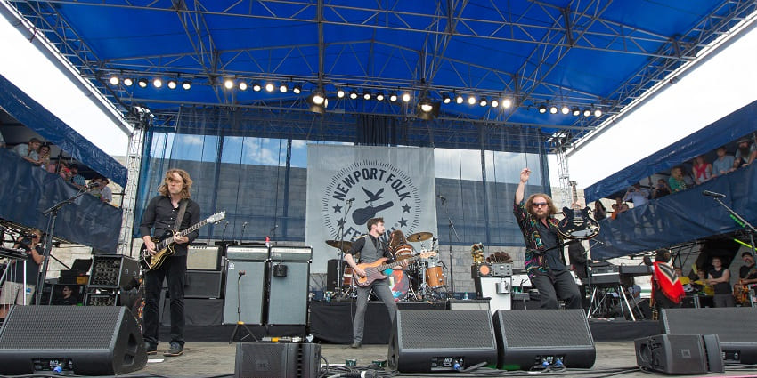 An image of the performers on stage at Newport Folk Festival with scenic waterfront views
