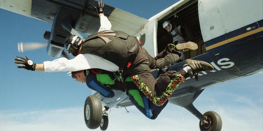 An image of a couple skydiving together over Niagara Falls, a skydiving spot in Canada.