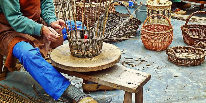 Image of a person weaving a basket with bamboo sticks - Explore Noida Haat with your partner
