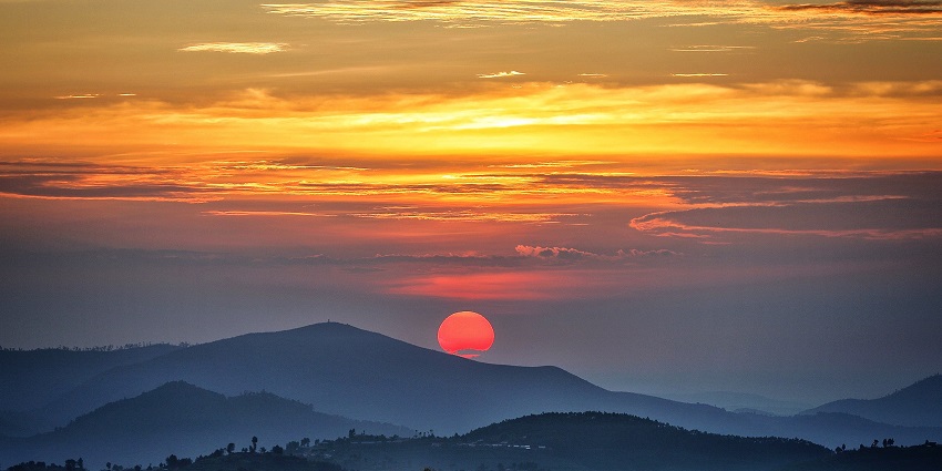 A beautiful reddish sun sets behind the hills in Nyungwe Forests, Southwestern Rwanda.