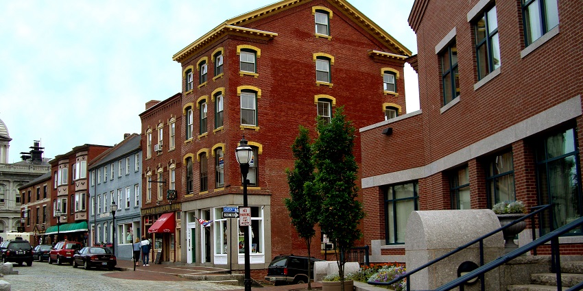 Cobblestone streets lined with historic buildings, shops, and bustling waterfront.