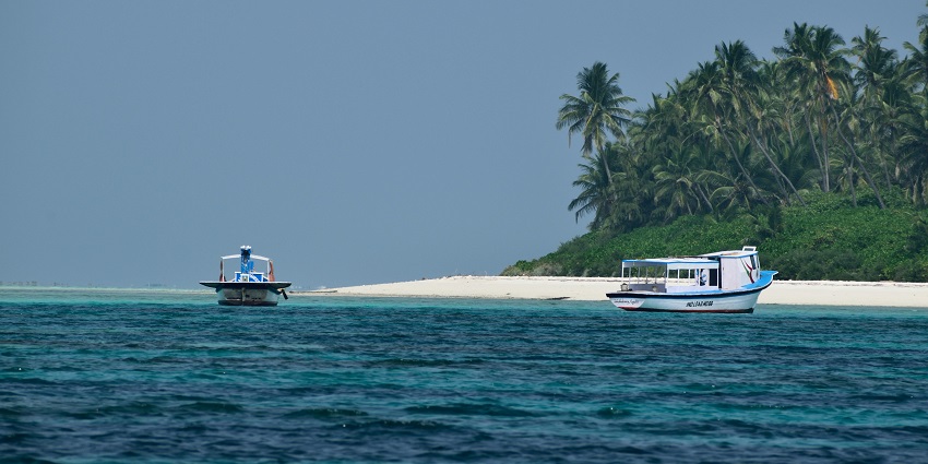 Image of Lakshadweep Island with turquoise colour water and a boat near the seashore