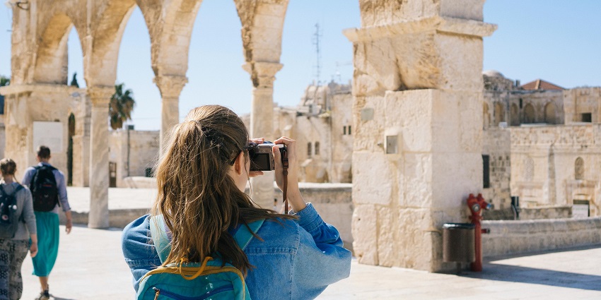 Women taking pictures of fort ruins - carry travel essentials according to the weather
