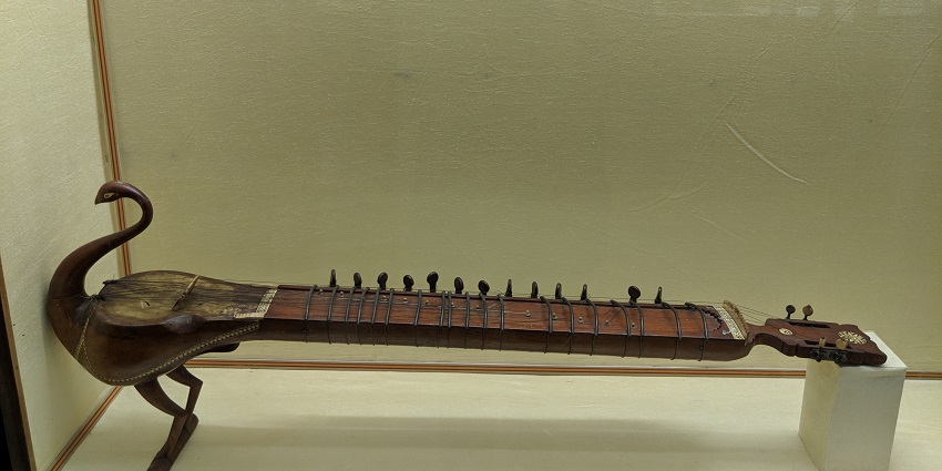 Image of the instrument is in the shape of a peacock. It is called "Taus" in North India