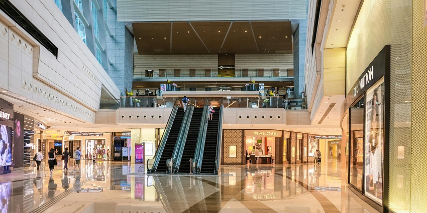 Image of a shopping mall with showrooms and people strolling around the mall