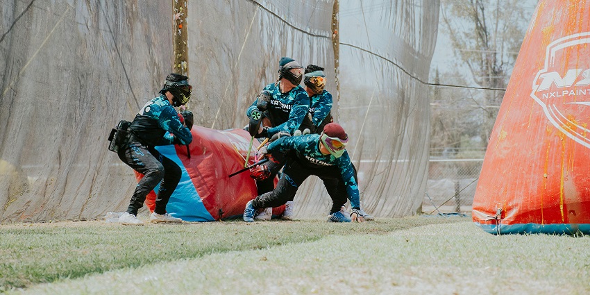 A representative image of people playing paintball, wearing protective gear and paintball guns