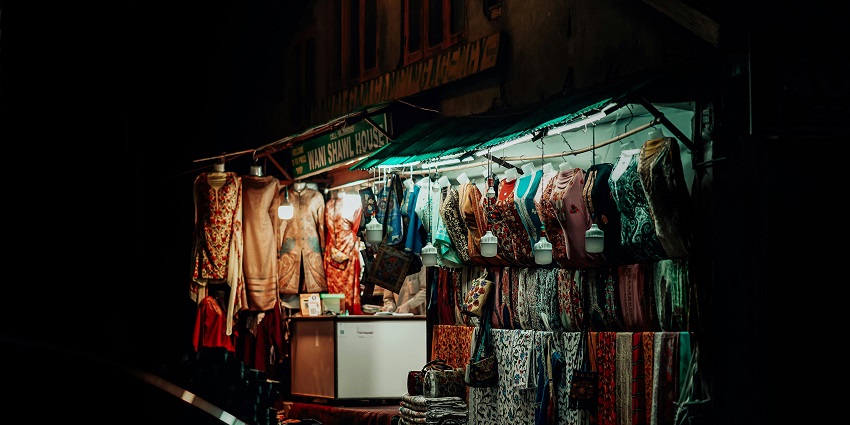 Image of Street Stall with Dresses at Night hanging in a market