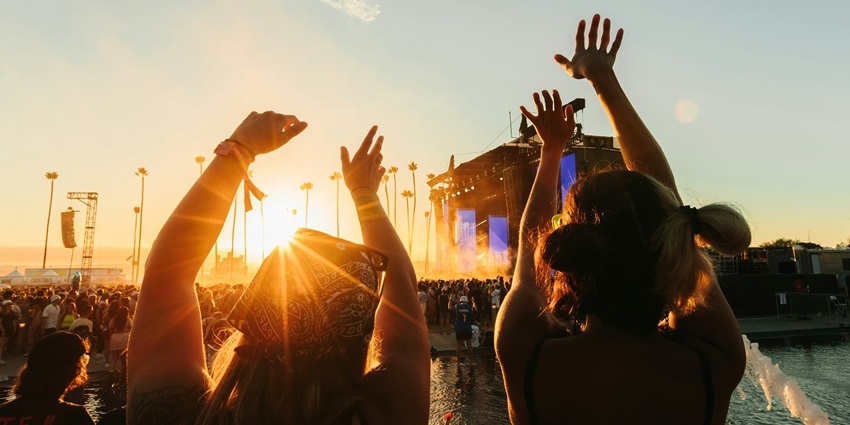 Image of people enjoying a music festival during sunset hour - enjoy the best music festival in April in the USA