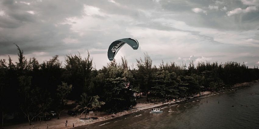 Paragliding in Gurgaon near Sohna above a lake surrounded by lush greenery