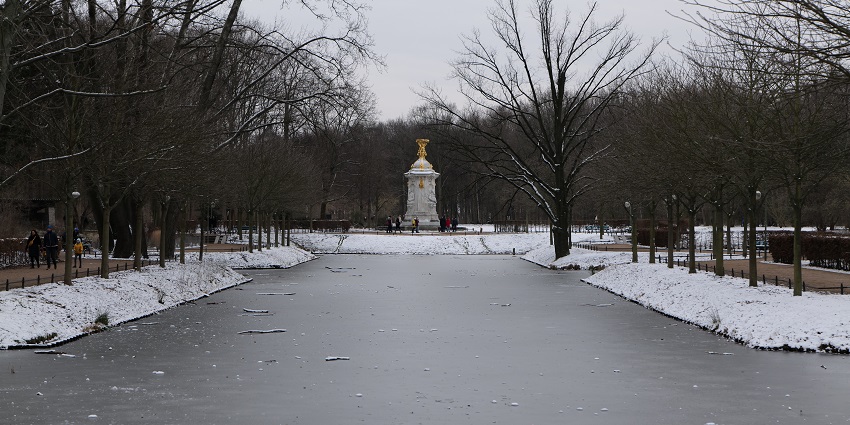 Tiergarten Park partially covered in ice and snow with people and a statue in the middle