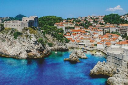 A historic stone façade of Pula Town Hall in Croatia, captured under a bright blue sky