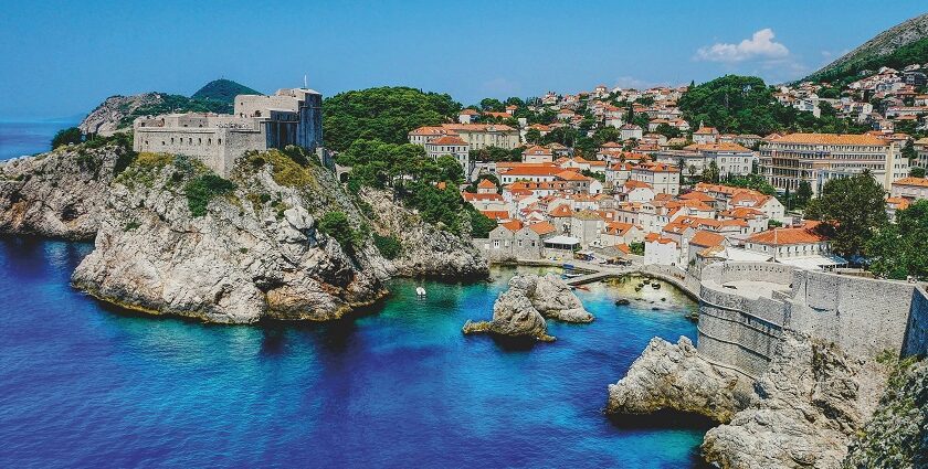 A historic stone façade of Pula Town Hall in Croatia, captured under a bright blue sky