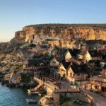 Beautiful houses on the sea shore are looking like a fairytale scene with a hill behind.