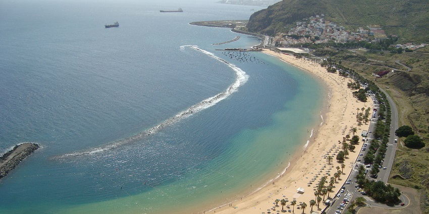 Golden sands, turquoise waters, and beach relaxation, featured in Tenerife travel guide.