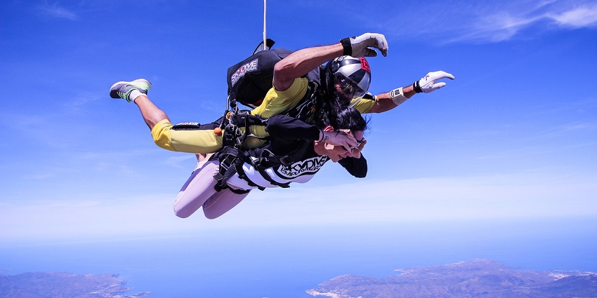 A picture of an exhilarating freefall with parachutes soaring over scenic landscapes.