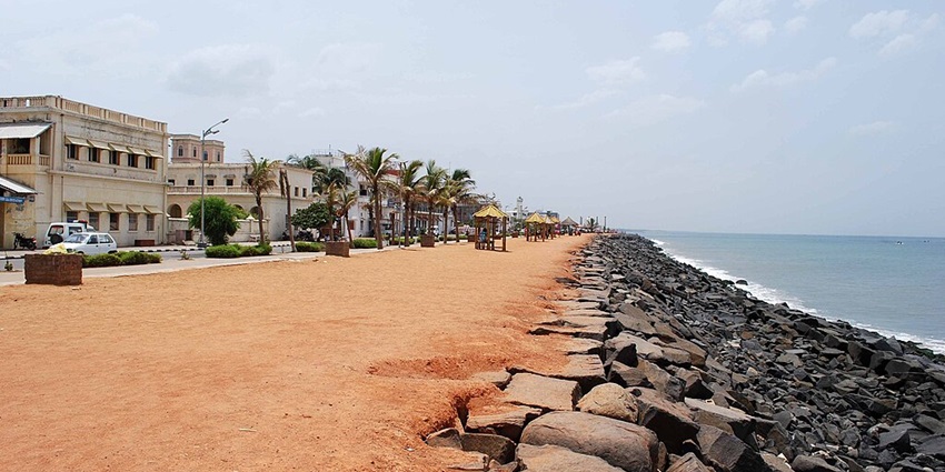 An image of Promenade Beach with tourists enjoying the view of the sea and sunset.