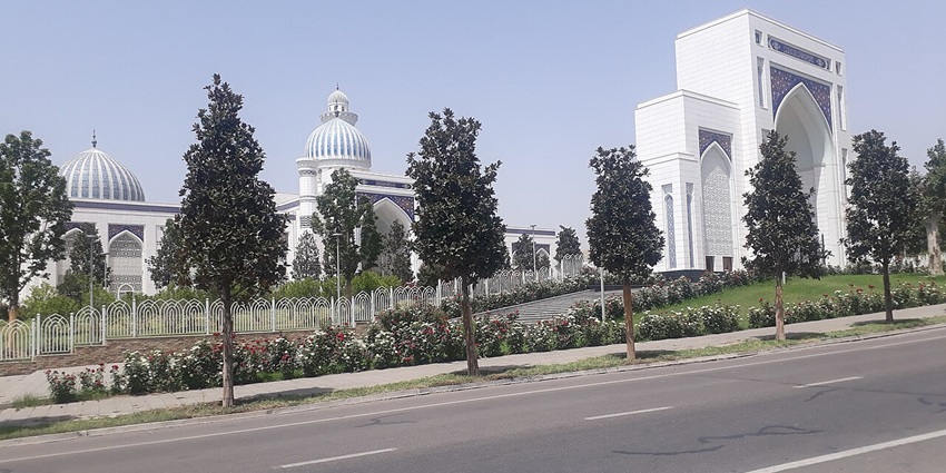Qawra mosque with a tall white minaret, viewed from the main road.