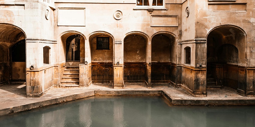 An image of Radha Kund alongside an old fort-style house that has a big Kund.