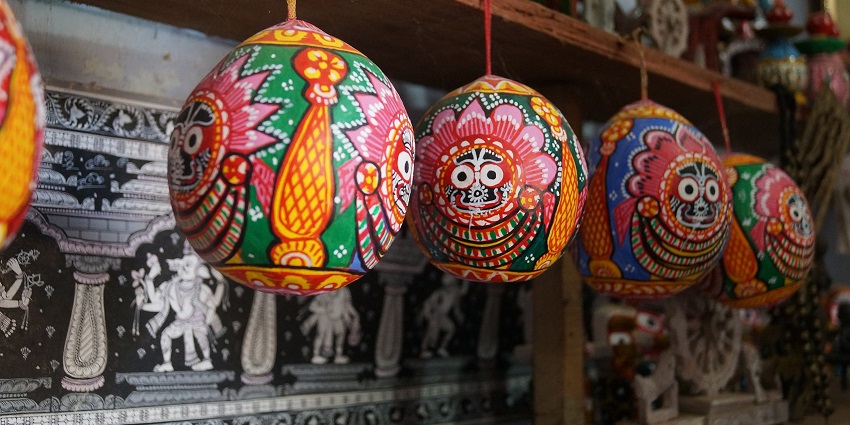 Colourful Illustrations of Lord Jagannath on betel nuts hanging at a shop in Raghurajpur Village, as suggested in the Odisha travel guide.