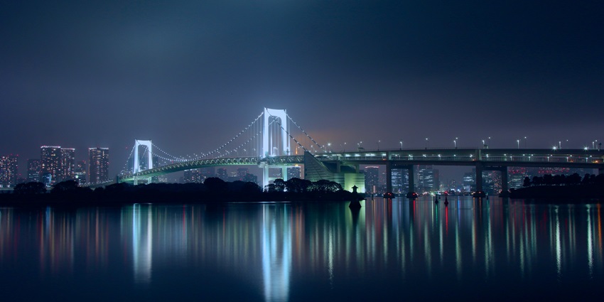Famous Rainbow Bridge in Tokyo, Japan illuminated for breathtaking views.