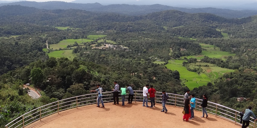 An expansive form the Raja’s Seat shows lush green hills with tourists in the foreground.