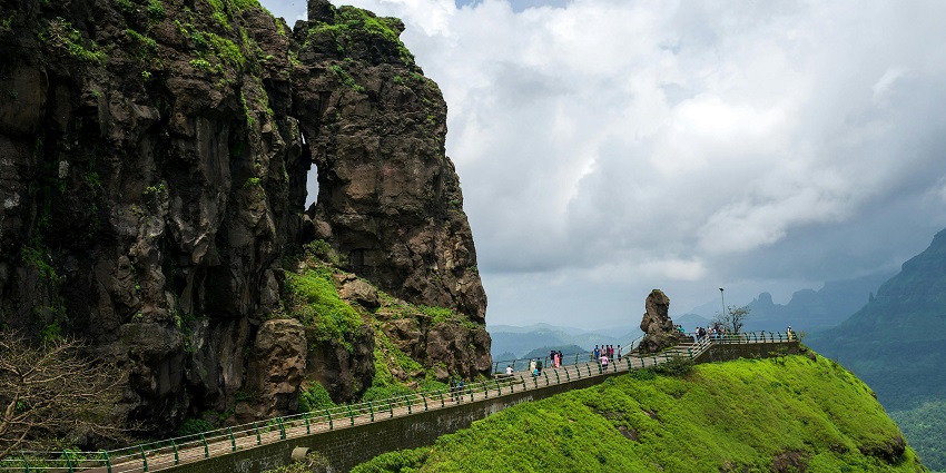 A picture of a mountain range captured with a striking lion's head rock from the tall peaks.