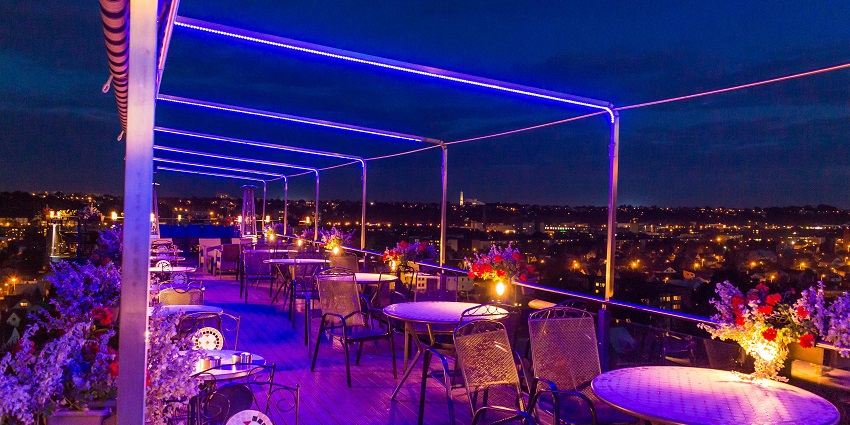 Picturesque view of a rooftop restaurant with round Gray Table With Two Chairs