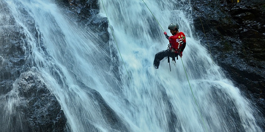 A picture of a person captures an adventurous and challenging rappelling activity in a vibrant way