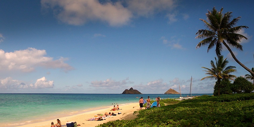 People relax on a sunny day at a picturesque Lanikai Beach in Kailua, Hawaii.