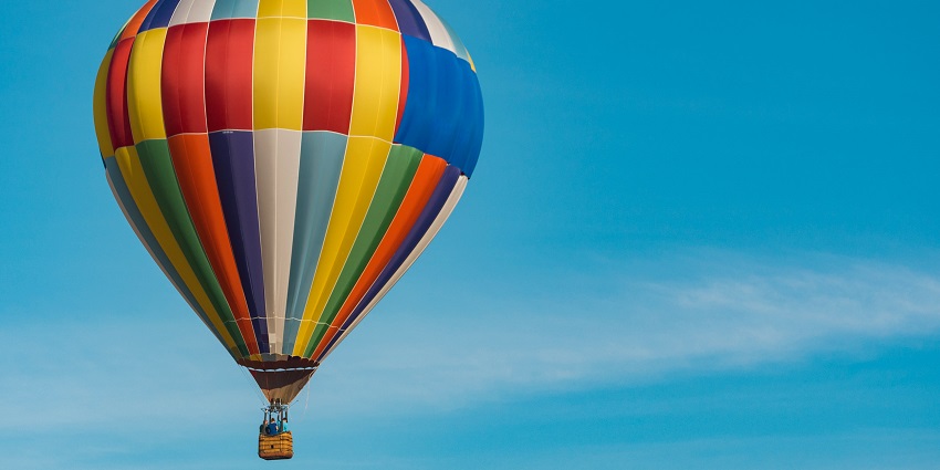 Stockholm from above with multiple hot air balloons flying over the archipelago.